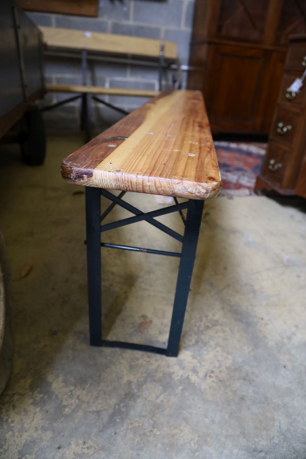 A pine and metal trestle garden table and a pair of benches, 176cm